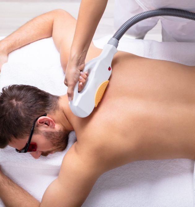 Close-up Of Man Receiving Laser Epilation Treatment By Beautician In Spa